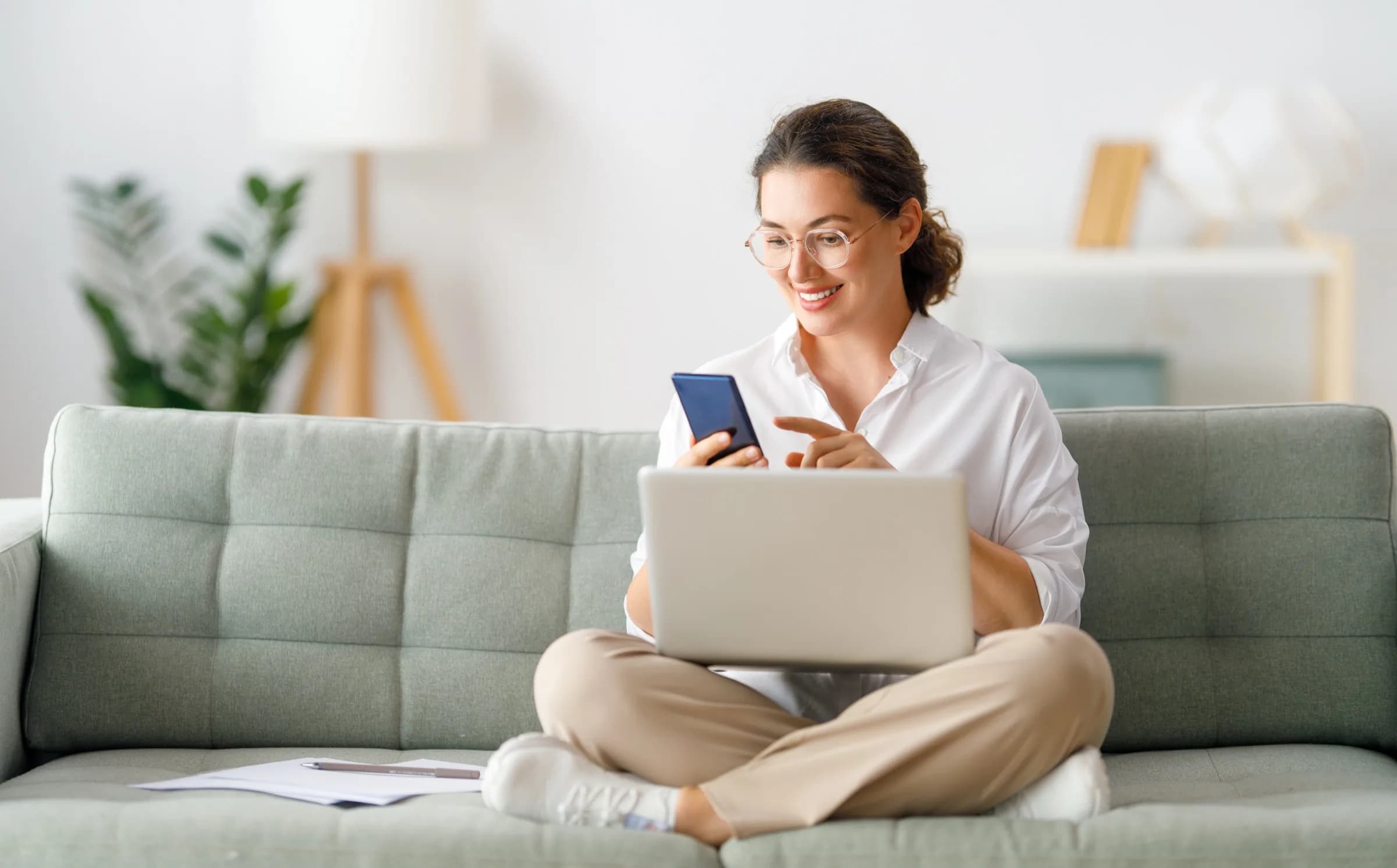 Eigentümerin mit Laptop und Smartphone zu Hause